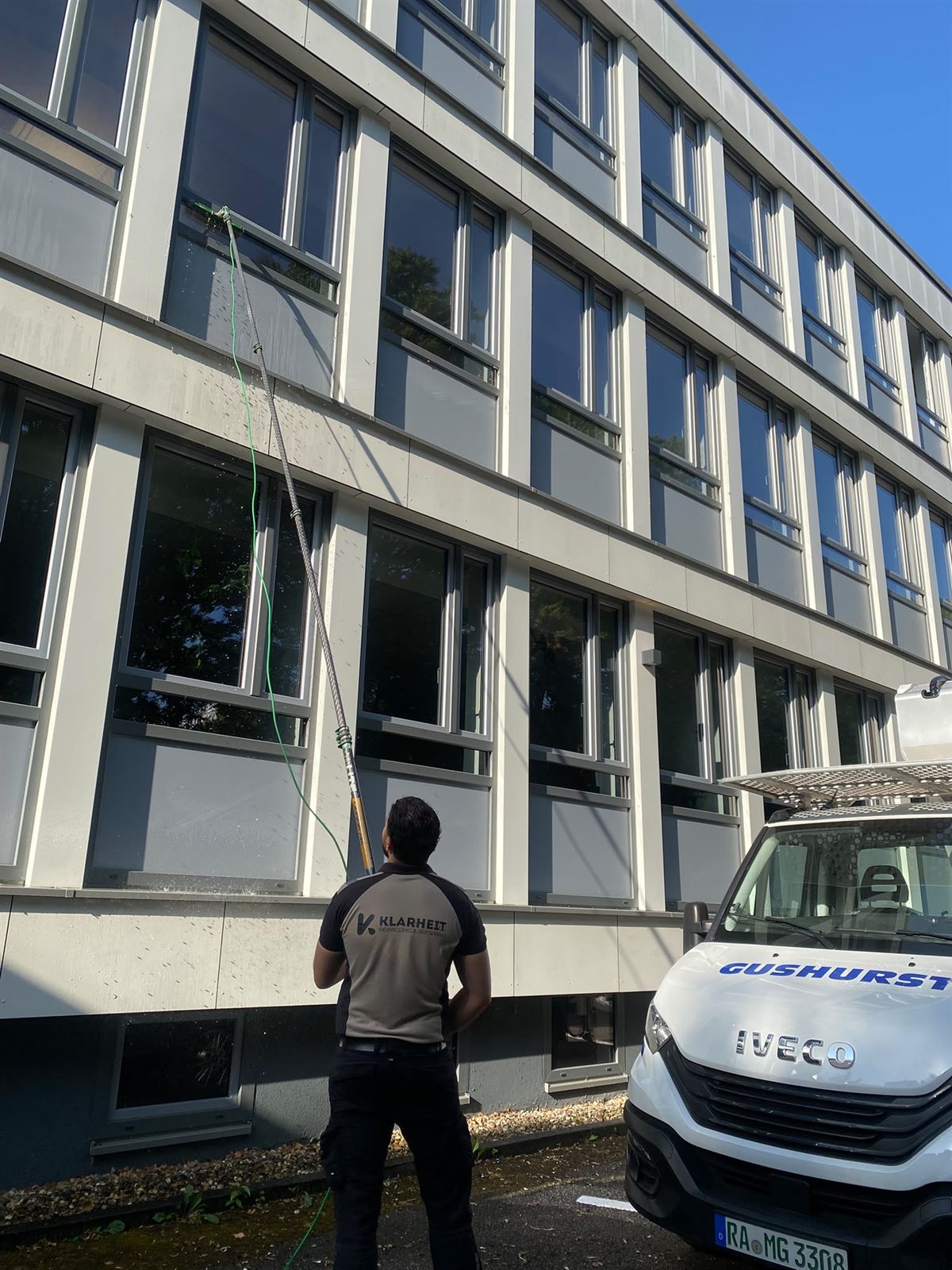 Klarheit Mitarbeiter bei der Fensterreinigung mit dem Osmose-Verfahren und Teleskopstange